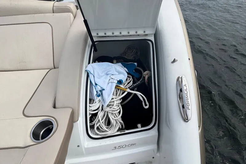 Slide: The Image of 2013 Formula 350 CBR boat storage compartment with ropes and towel by the water. - 51