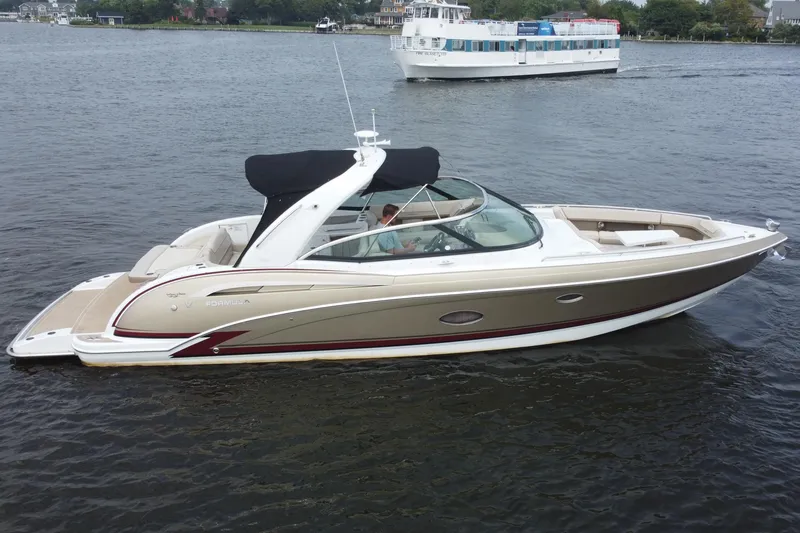 Slide: The Image of 2013 Formula 350 CBR boat cruising on a calm river with a ferry in the background. - 8