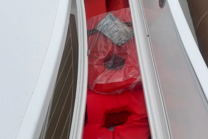 Slide: The Image of Storage compartment with red life jackets on a 2016 Buddy Davis 28 Center Console boat. - 10