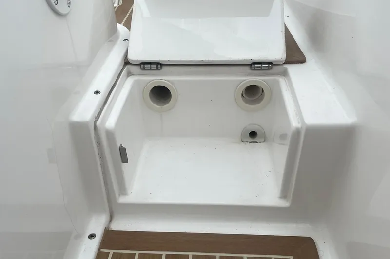 Slide: The Image of 2016 Buddy Davis 28 Center Console boat compartment with drainage holes and white finish. - 11