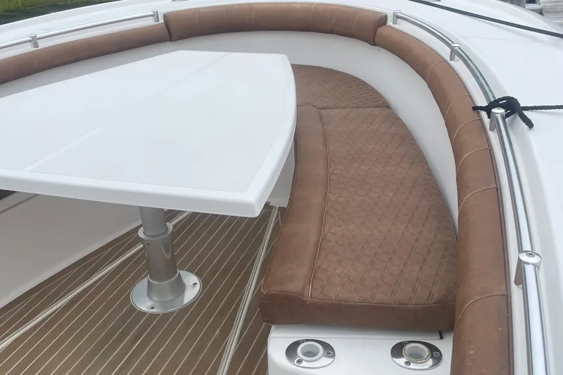 Slide: The Image of 2016 Buddy Davis 28 Center Console boat interior with cushioned seating and table. - 15