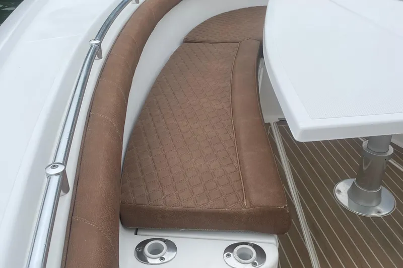Slide: The Image of 2016 Buddy Davis 28 Center Console boat with brown cushioned seating and white table. - 16