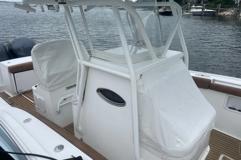 Slide: The Image of 2016 Buddy Davis 28 Center Console boat with covered seating, docked by the water. - 26