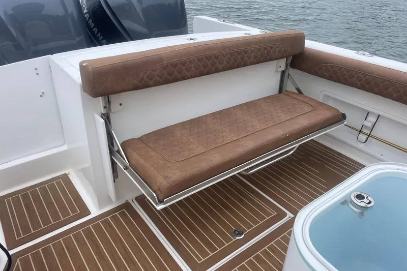 Slide: The Image of 2016 Buddy Davis 28 Center Console boat with brown cushioned seating and teak flooring. - 3