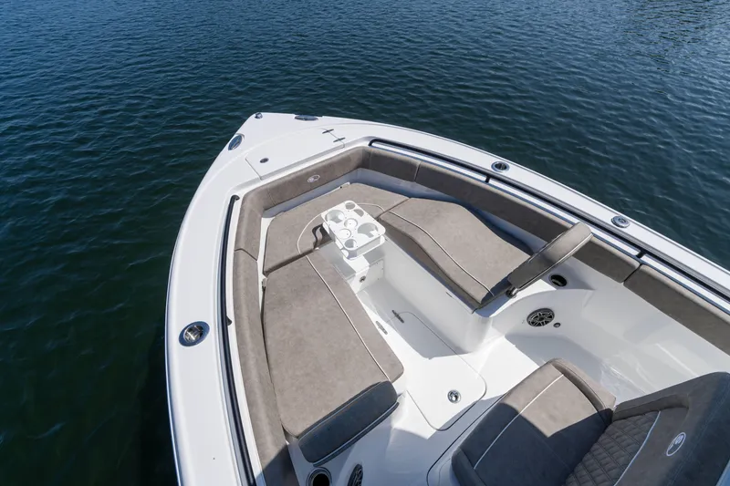 Slide: The Image of 2026 Sea Hunt Ultra 255 SE boat with cushioned seating on calm water. - 17