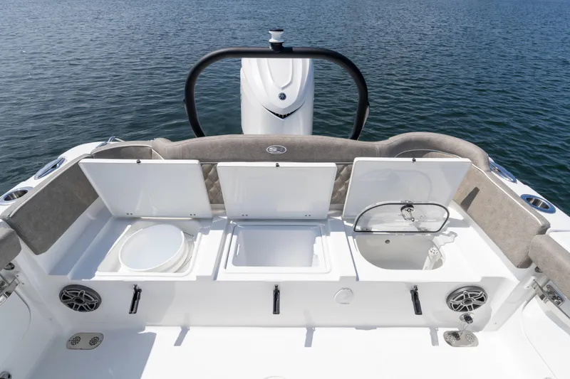 Slide: The Image of 2026 Sea Hunt Ultra 255 SE boat interior with open storage compartments on calm water. - 19