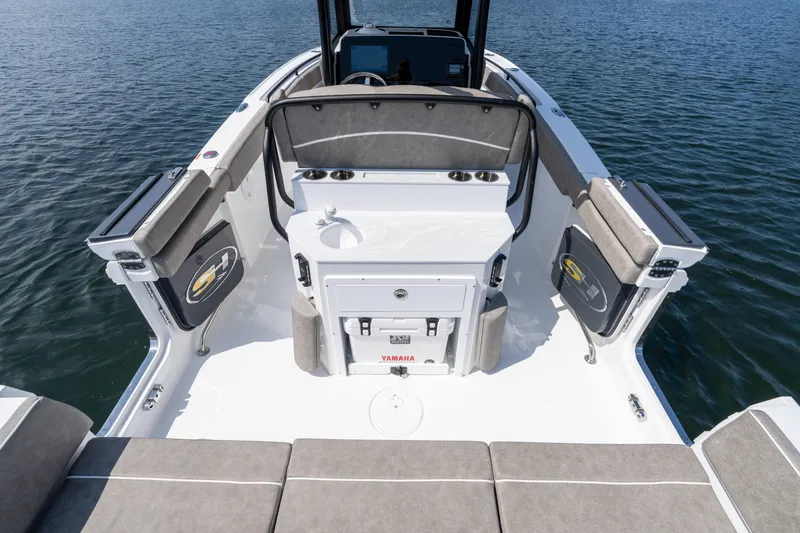 Slide: The Image of 2026 Sea Hunt Ultra 255 SE boat interior with seating and storage, on calm water. - 3