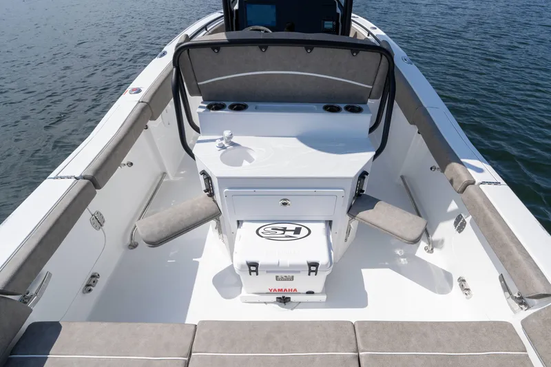 Slide: The Image of 2026 Sea Hunt Ultra 255 SE boat interior with seating and storage, on calm water. - 4