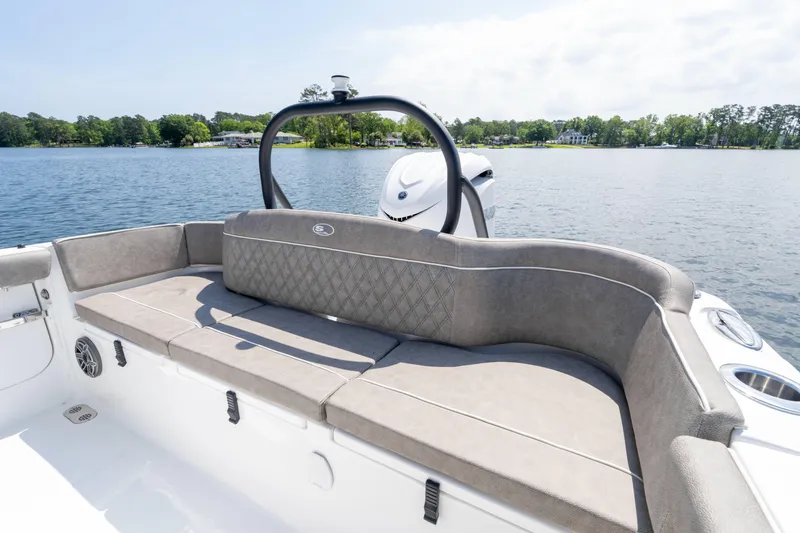 Slide: The Image of 2026 Sea Hunt Ultra 255 SE boat interior with cushioned seating, on a serene lake. - 7