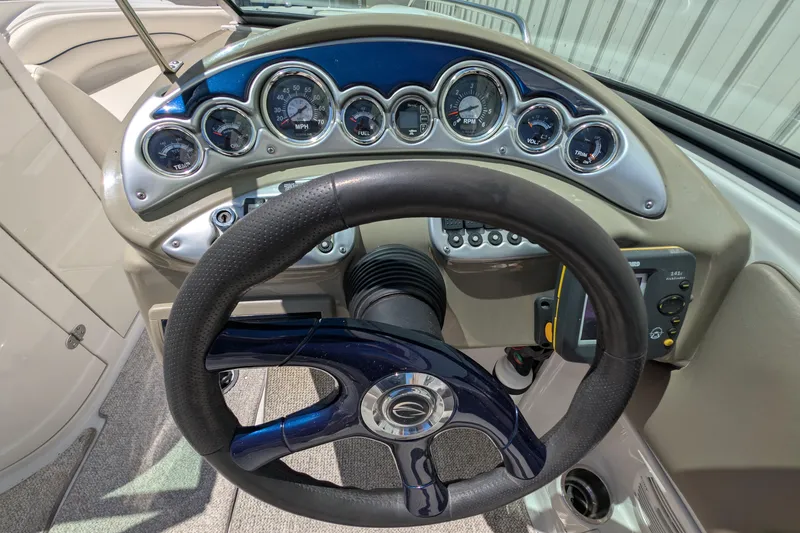 Slide: The Image of Steering wheel and dashboard of 2006 Crownline 240 EX boat, featuring gauges and controls. - 12