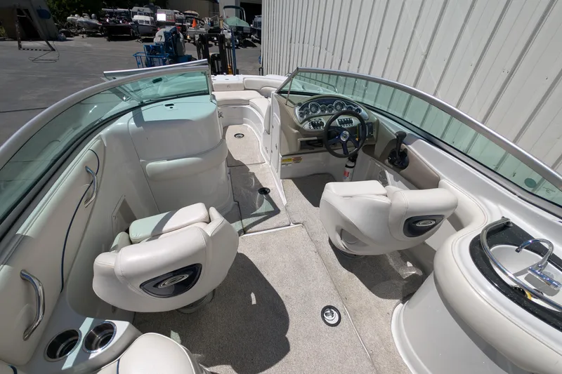 Slide: The Image of 2006 Crownline 240 EX boat interior with steering wheel, seating, and sink. - 22