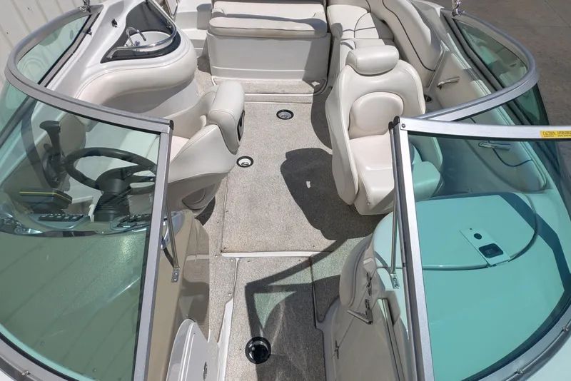 Slide: The Image of 2006 Crownline 240 EX boat interior with seating and steering wheel, featuring spacious layout. - 9