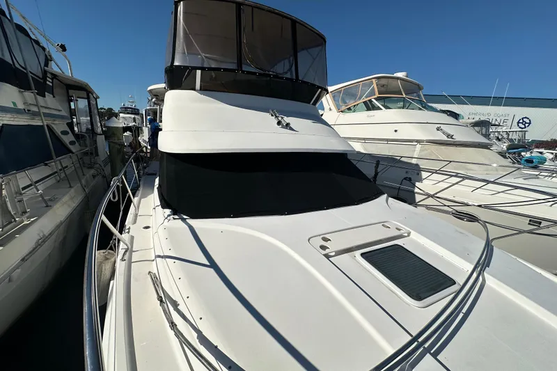 Slide: The Image of 1999 Silverton 442 Cockpit Motor Yacht docked at marina under clear blue sky. - 11