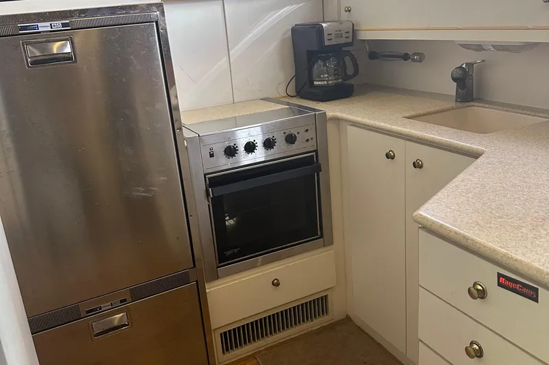 Slide: The Image of Compact kitchen in 1999 Silverton 442 Cockpit Motor Yacht with appliances and cabinetry. - 21