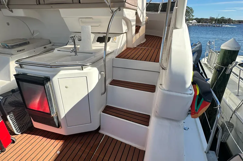 Slide: The Image of 1999 Silverton 442 Cockpit Motor Yacht interior with wooden steps and kitchenette. - 27