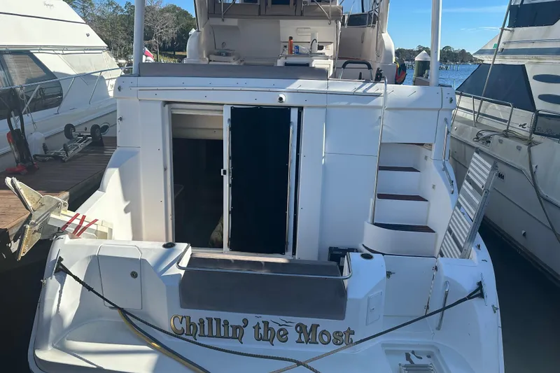 Slide: The Image of 1999 Silverton 442 Cockpit Motor Yacht docked, rear view with "Chillin' the Most" text. - 32