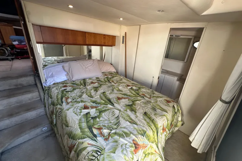 Slide: The Image of 1999 Silverton 442 Cockpit Motor Yacht bedroom with tropical bedding and cozy interior. - 5