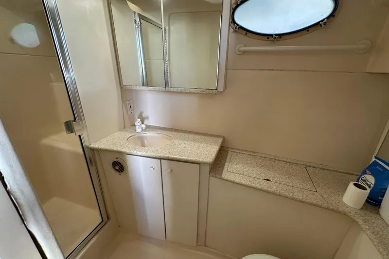Slide: The Image of 1999 Silverton 442 Cockpit Motor Yacht bathroom with sink, mirror, and shower. - 6