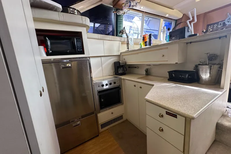Slide: The Image of 1999 Silverton 442 Cockpit Motor Yacht kitchen with modern appliances and ample counter space. - 7
