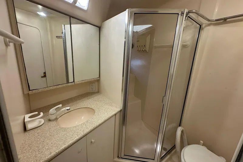 Slide: The Image of 1999 Silverton 442 Cockpit Motor Yacht bathroom with shower, sink, and mirror. - 8