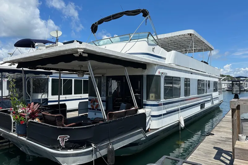 The Image of 1990 Sumerset 14x65 houseboat docked at marina under clear blue sky. - 0