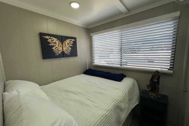 Slide: The Image of Cozy bedroom in 1990 Sumerset 14x65 houseboat with butterfly artwork and large window blinds. - 6