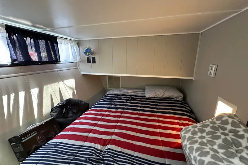 Slide: The Image of Cozy bedroom in 1990 Sumerset 14x65 houseboat with striped bedding and natural light. - 7