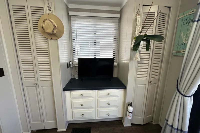 Slide: The Image of Interior of 1990 Sumerset 14x65 houseboat with TV, cabinets, and decor. - 9