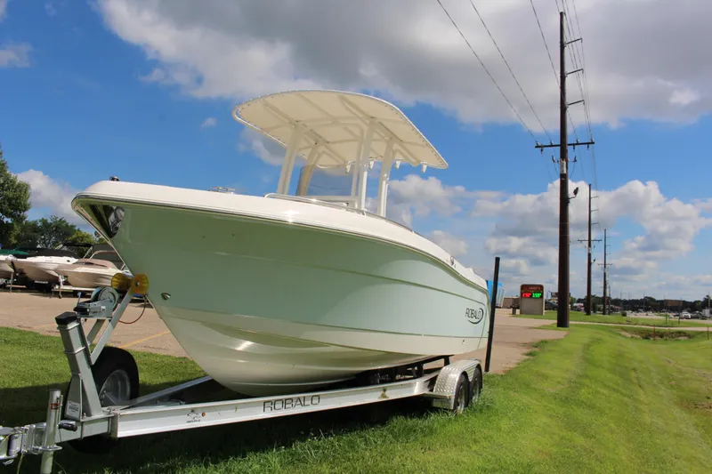 Slide: The Image of 2023 Robalo R222 Center Console boat on trailer under blue sky. - 1