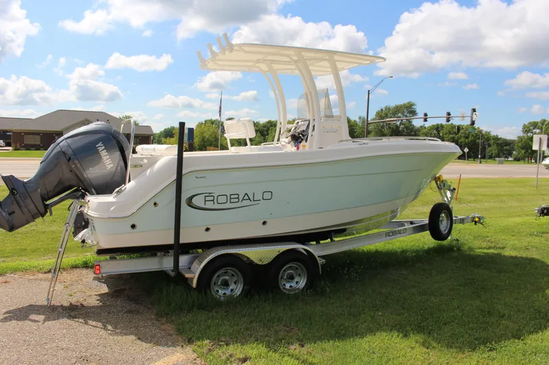 Slide: The Image of 2023 Robalo R222 Center Console boat on trailer, parked on grass under blue sky. - 20