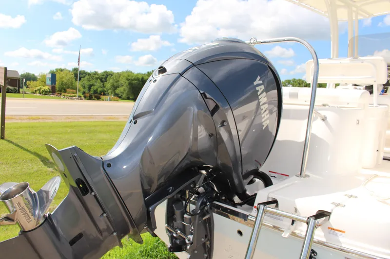Slide: The Image of 2023 Robalo R222 Center Console with Yamaha outboard motor, parked on grass. - 22