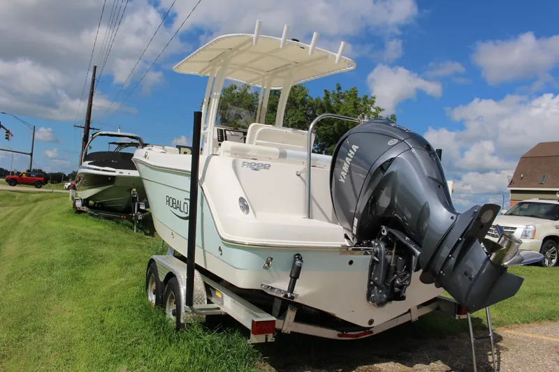 Slide: The Image of 2023 Robalo R222 Center Console boat with Yamaha engine on trailer, parked on grass. - 25