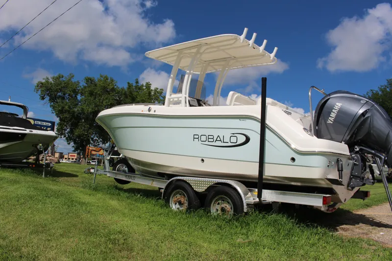Slide: The Image of 2023 Robalo R222 Center Console boat on trailer, grassy area, clear sky. - 26