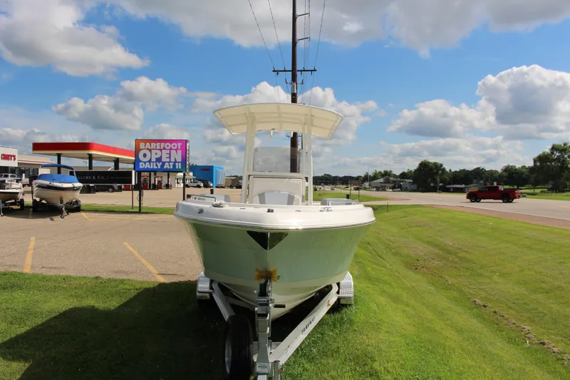 Slide: The Image of 2023 Robalo R222 Center Console boat on trailer, parked near a roadside. - 27
