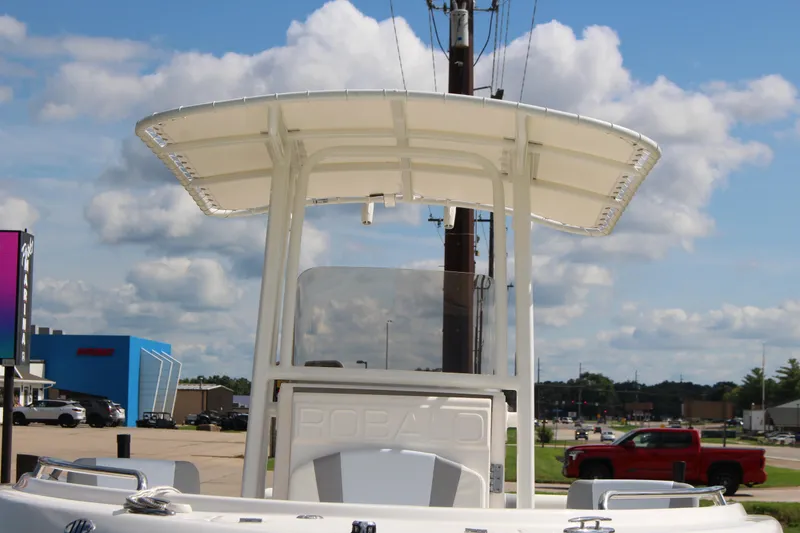 Slide: The Image of 2023 Robalo R222 Center Console boat with T-top, parked outdoors under a cloudy sky. - 28
