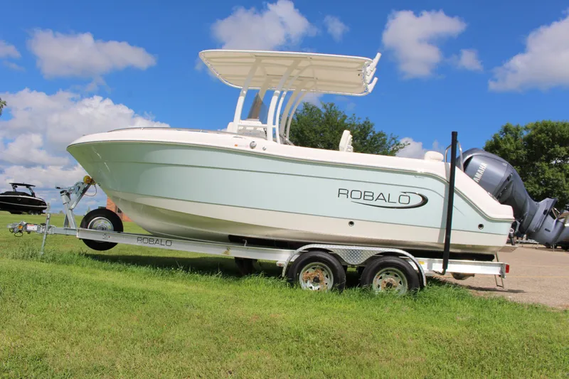 Slide: The Image of 2023 Robalo R222 Center Console boat on trailer, parked on grass under blue sky. - 3