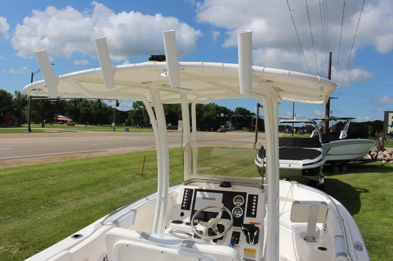Slide: The Image of 2023 Robalo R222 Center Console boat with T-top, parked on grass near a road. - 31