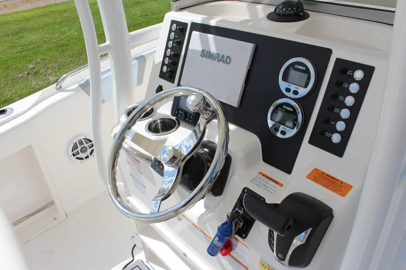 Slide: The Image of 2023 Robalo R222 Center Console boat dashboard with steering wheel and controls. - 33