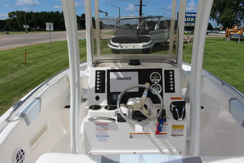Slide: The Image of 2023 Robalo R222 Center Console boat dashboard with steering wheel and controls. - 4