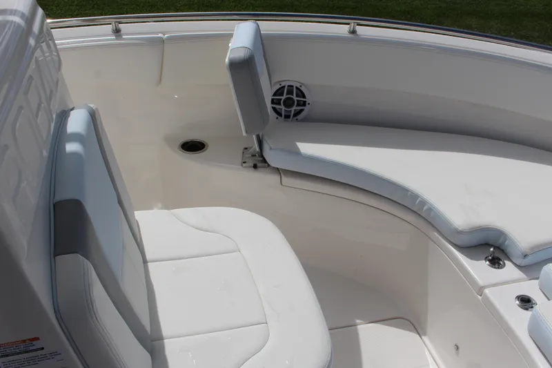 Slide: The Image of 2023 Robalo R222 Center Console boat seating area with white cushions and speaker. - 5