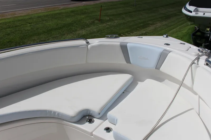 Slide: The Image of 2023 Robalo R222 Center Console boat with white cushioned seating area. - 9