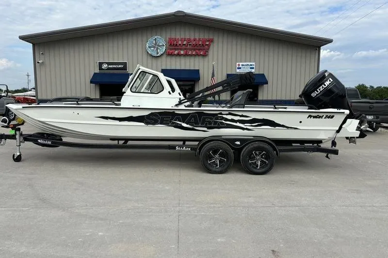 The Image of 2026 SeaArk ProCat 240 boat with Suzuki engine, displayed at a marine dealership. - 1
