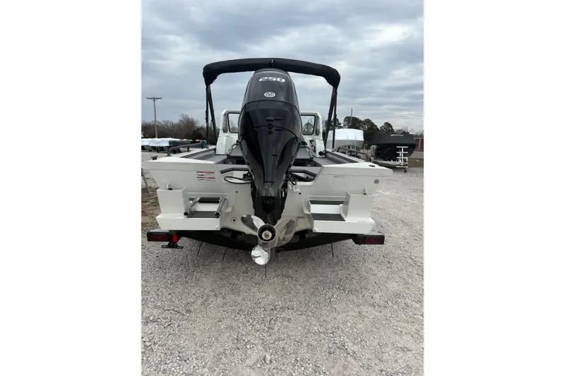 Slide: The Image of 2026 SeaArk ProCat 240 boat with powerful outboard motor, parked on gravel. - 9