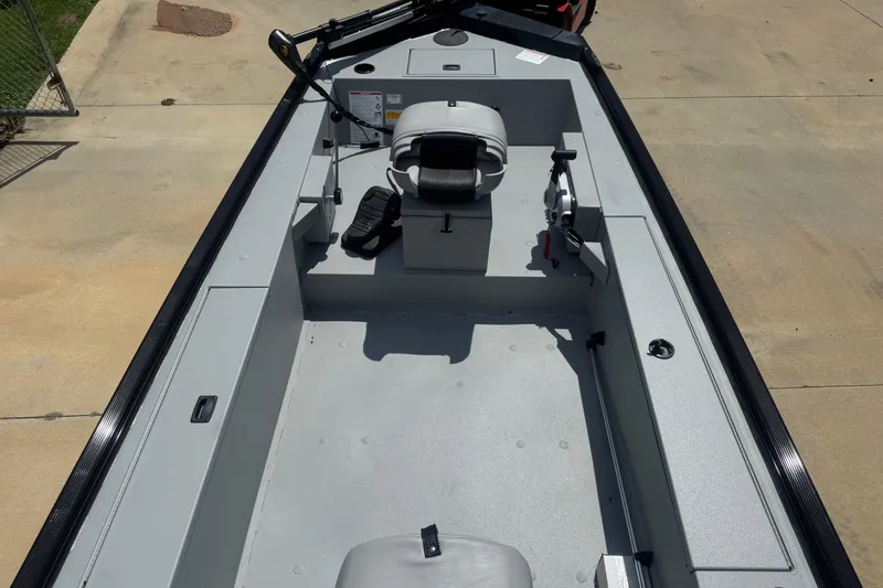 Slide: The Image of 2025 Crestliner 1657 Outlook Stick Steer boat interior with control panel and storage compartment. - 7