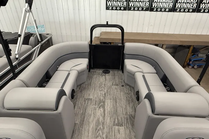 Slide: The Image of 2026 Bentley Pontoons Legacy 243 Navigator interior with gray seating and wood-style flooring. - 16