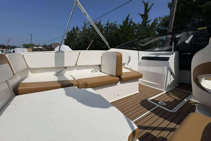 Slide: The Image of 2020 Bayliner VR4 Bowrider OB interior with white and brown seating, wood-style flooring. - 10