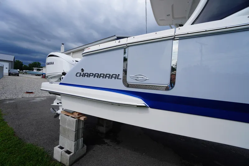 Slide: The Image of 2025 Chaparral 280 OSX boat on blocks, featuring sleek design and Yamaha engine. - 13