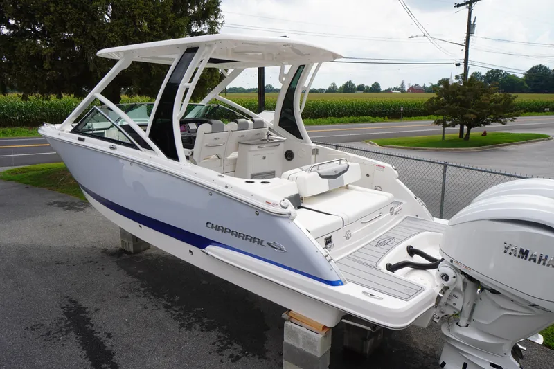 Slide: The Image of 2025 Chaparral 280 OSX boat with Yamaha engine, parked outdoors on a sunny day. - 2