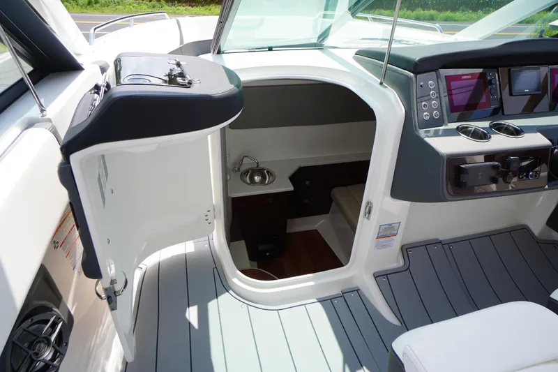 Slide: The Image of 2025 Chaparral 280 OSX boat interior with open cabin door and modern dashboard. - 26