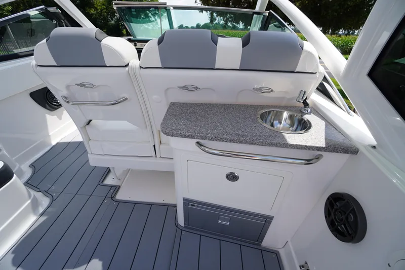 Slide: The Image of 2025 Chaparral 280 OSX boat interior with seating, sink, and modern design features. - 33